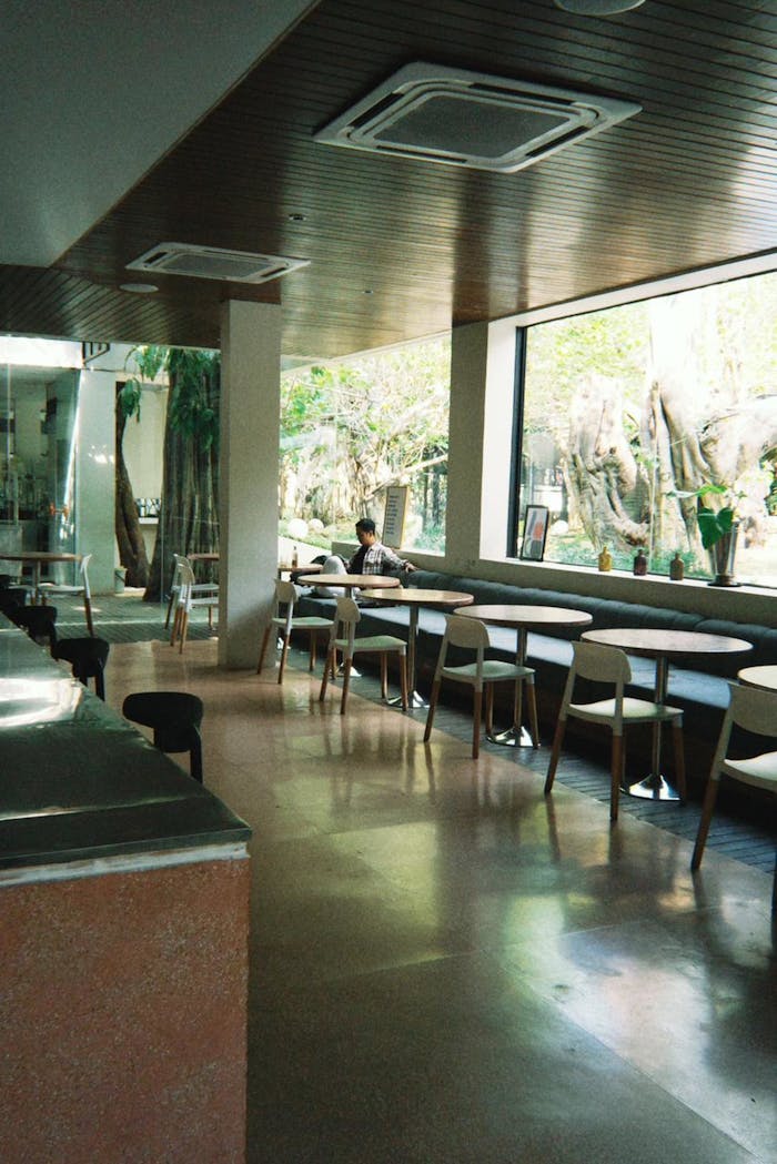 hero-img-02 A serene and stylish cafe interior in Semarang, featuring minimalist design and large windows.
